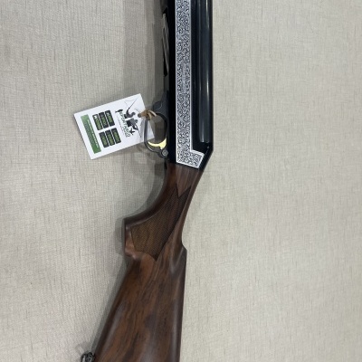 Espingarda com coronha em madeira castanha e detalhes gravados em metal prateado