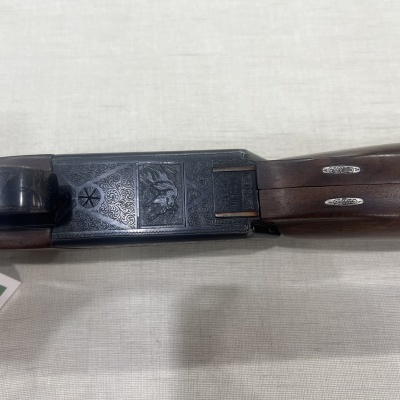 Espingarda de caça com caixa metálica gravada e coronha em madeira escura