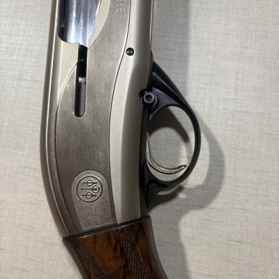 Parte de arma de fogo Beretta com metal prateado e cabo de madeira castanha