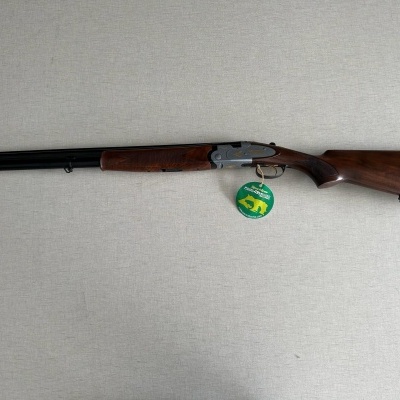 Espingarda de canos duplos com coronha em madeira castanha e acabamento metálico