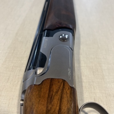 Espingarda com madeira castanha e metal prateado marcada com 'C92'