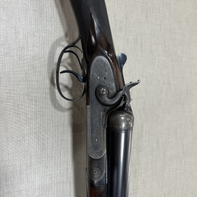 Espingarda de canos paralelos com coronha de madeira e detalhes metálicos