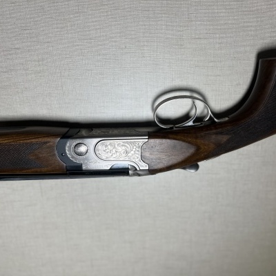 Espingarda de caça com madeira e metal detalhado em fundo branco