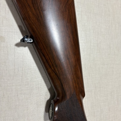 Espingarda com coronha em madeira castanha escura e empunhadura texturizada