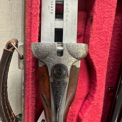 Espingarda dupla com madeira e metal gravado em base forrada a veludo vermelho