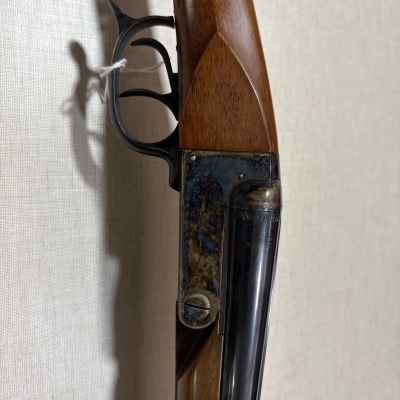 Espingarda com corpo em madeira castanha e armação metálica marmoreada azul e castanha