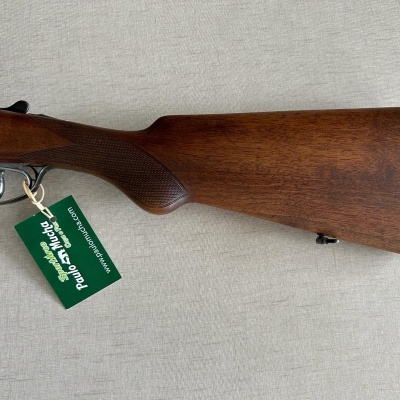 Espingarda com cabo de madeira castanha e etiqueta verde