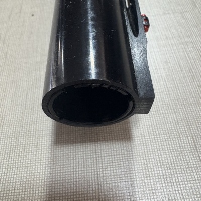 tubo preto cilíndrico visto pela extremidade aberta sobre superfície quadriculada clara