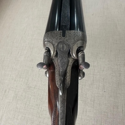 Espingarda de canos duplos com detalhes em madeira e metal gravado