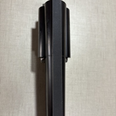 Parte superior de objeto preto com tubos cilíndricos e textura quadriculada
