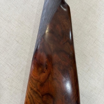 Coronha de espingarda em madeira castanho escuro com textura e padrão texturizado