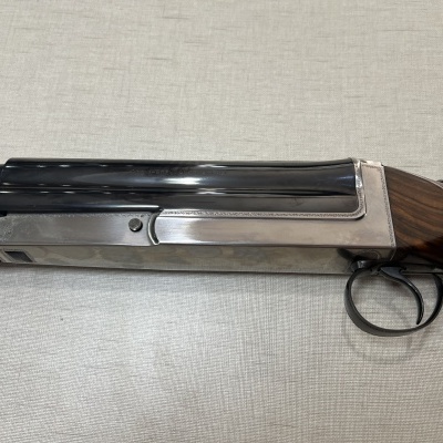 Espingarda de caça madeira e metal sobre superfície clara.