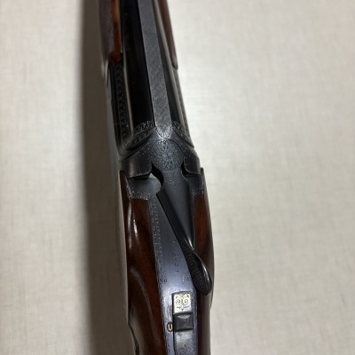 Rifle de madeira escura com detalhes em metal gravado