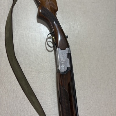 Espingarda de caça com madeira castanha e detalhes em metal prateado