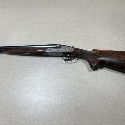 Espingarda de canos duplos com coronha de madeira escura