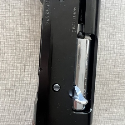 Parte superior de espingarda em metal preto e prata com madeira e inscrições MONTEFERRO e NO92878.