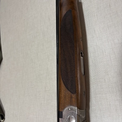 Espingarda gravada BERETTA de madeira e metal sobre fundo claro texturizado