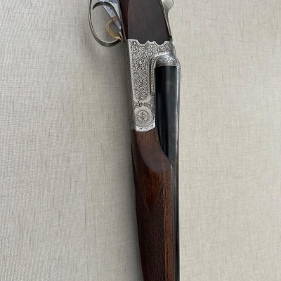 Espingarda de canos duplos em madeira castanha e metal prateado gravado