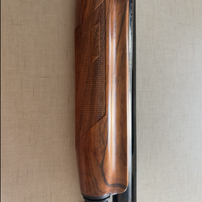 Parte de espingarda com cabo em madeira e inscrição 'Beretta'