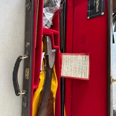 Estojo aberto com espingarda e forro vermelho e amarelo