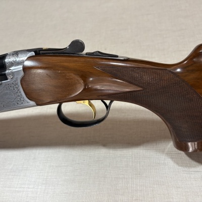Espingarda com madeira castanha polida e entalhes metálicos prateados decorativos
