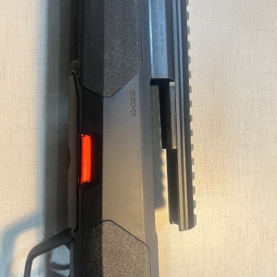 Rifle ou espingarda cinza e preto com alavanca de segurança vermelha e trilho superior