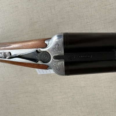 Espingarda de dois canos paralelos com punho de madeira e metal gravado