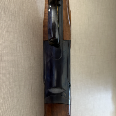 Punho de madeira e corpo metálico de arma de fogo