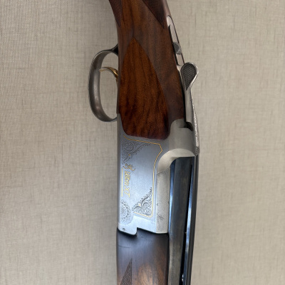 Rifle de caça com coronha em madeira castanha polida e corpo metálico prateado com gravações decorativas Ultra XT