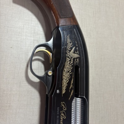Caça com coronha em madeira castanha com detalhes gravados e texto P. Beretta MADE IN ITALY