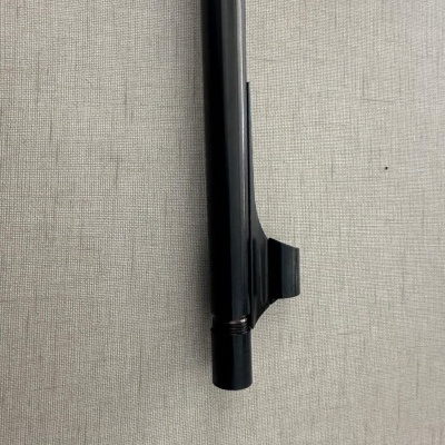 peça cilíndrica metálica preta com acabamento brilhante e roscas sobre tecido cinzento