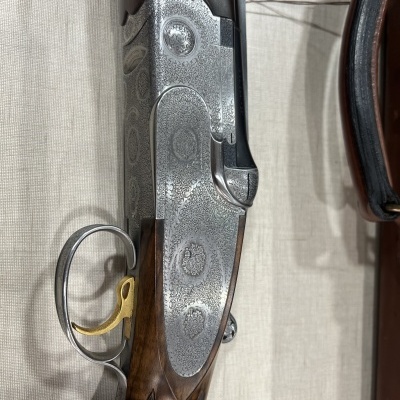 Arma de caça com madeira e metal gravado