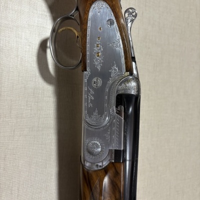 Espingarda de cano duplo com madeira castanha e detalhes metálicos gravados