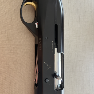 Parte central de espingarda preta com madeira e gatilho dourado