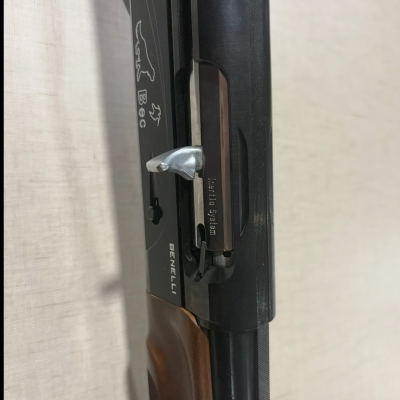 Espingarda Benelli com corpo preto e cabo de madeira