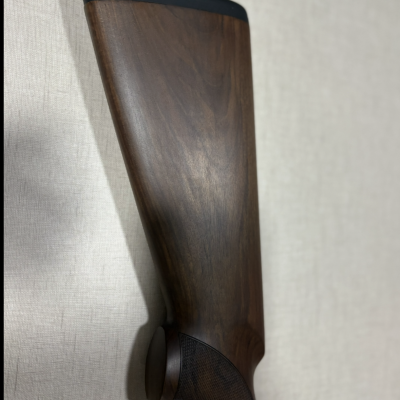 Parte traseira de espingarda em madeira escura com extremidade preta