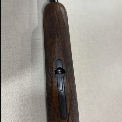 Parte de uma arma de fogo de madeira com acabamento e peça metálica