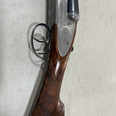 Espingarda de caça com madeira castanha e gravações metálicas