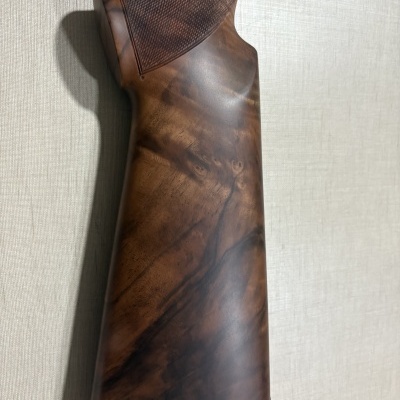 Coronha de arma de fogo em madeira castanha com acabamento quadriculado e borracha vermelha na base