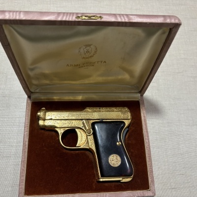 Pistola dourada gravada em estojo acolchoado creme e castanho