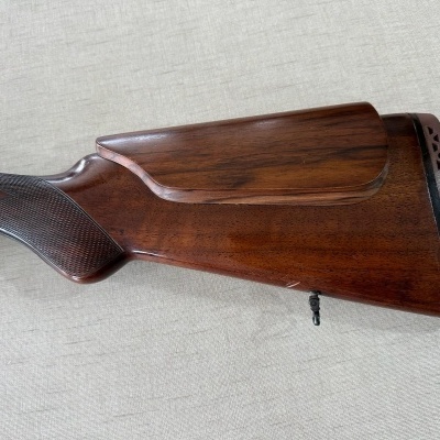 Espingarda de madeira castanha com empunhadura gravada e borracha preta no final