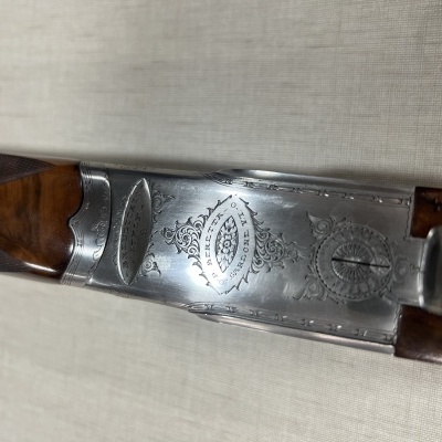 Espingarda com caixa prateada gravada e empunhadura de madeira escura