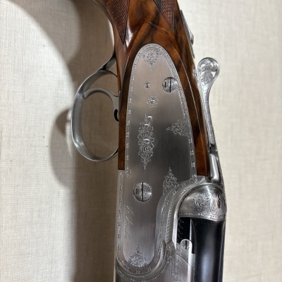 Arma de fogo de madeira e metal com gravações ornamentais