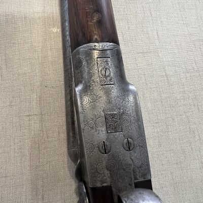 Espingarda antiga com cano de madeira e detalhes metálicos gravados