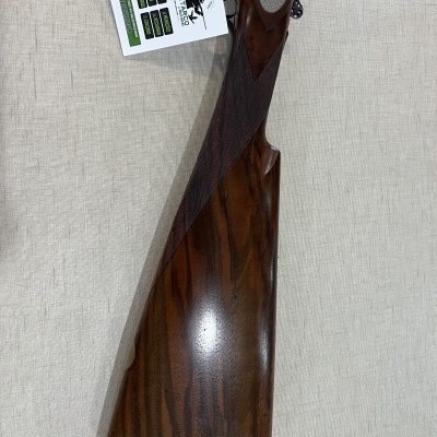 Coronha de espingarda em madeira castanha com textura quadriculada e apoio almofadado cinza