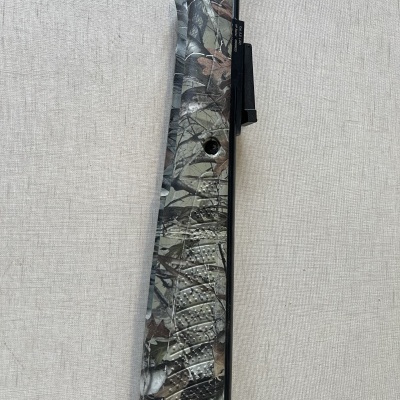 Peça de arma camuflada contra fundo cinzento