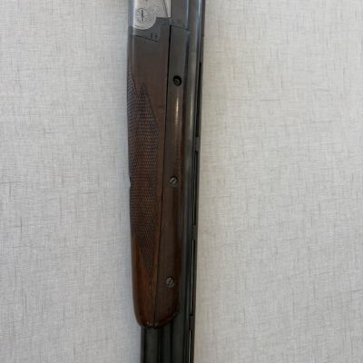 Espingarda com madeira escura texturizada e metal prateado gravado