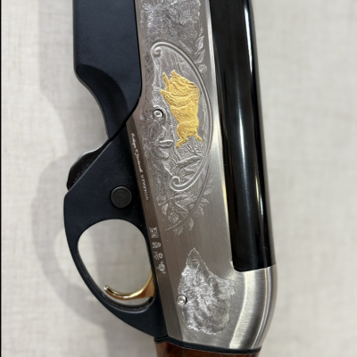 Parte de espingarda com detalhes em madeira, metal e gravuras de animais.