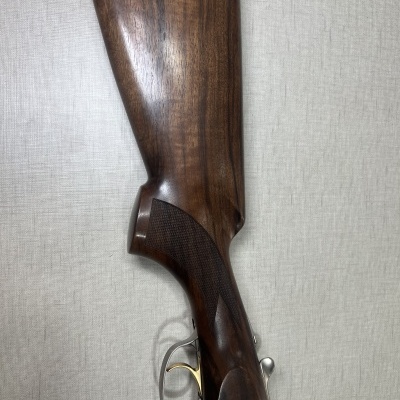 Empunhadura de arma de fogo em madeira castanha escura com gatilho metálico