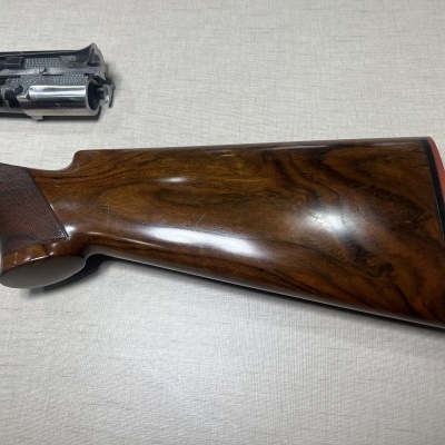 Espingarda com coronha de madeira castanha e tubo metálico preto